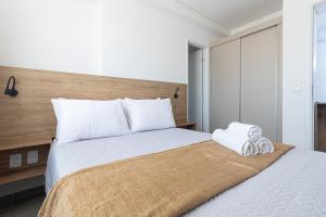 una camera da letto con un letto con due asciugamani sopra di Andrea Priori em Boa Viagem By Carpediem a Recife