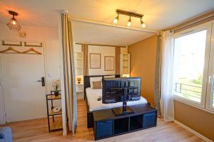 a bedroom with a bed and a television on a table at Le Cocon à 15 minutes de Disneyland Paris in Bussy-Saint-Georges