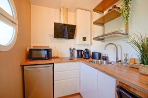 a small kitchen with a sink and a microwave at Le Cocon à 15 minutes de Disneyland Paris in Bussy-Saint-Georges +14 photos