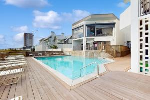 une piscine avec des chaises et une maison dans l'établissement Broadmoor 1203, à Orange Beach