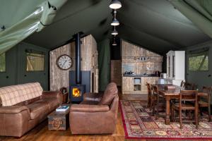TalybontにあるBwncath Glamping Lodgeのリビングルーム(ソファ、テーブル、暖炉付) +14枚の写真