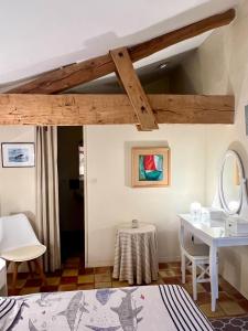 Zimmer mit einem Bett, einem Waschtisch und einem Spiegel in der Unterkunft Château Le Baudou in Coutras