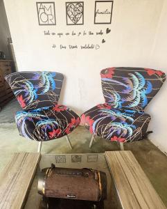 twee stoelen naast een muur met een laptop bij Por Do Sol Residence in Canoa Quebrada