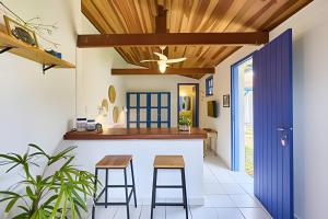 a kitchen with a counter and stools in a house at Chalé no Itaguá, ao lado do aquário de Ubatuba in Ubatuba