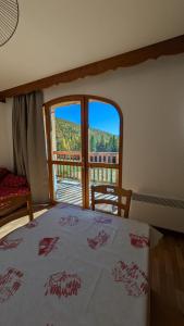 a bedroom with a bed and a large window at Appartement 4 pièces pour 6-8 personnes, 3 chambres, 2 canapés-lit double dans le salon, au pied des pistes et piscine l'été, wifi fibre in Arvieux