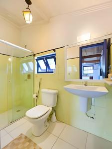 a bathroom with a toilet and a sink at Chalé no Itaguá, ao lado do aquário de Ubatuba in Ubatuba +68 photos