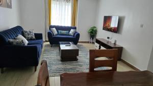 a living room with two blue couches and a table at Tulivu homes in Ongata Rongai 