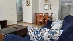 a living room with a blue couch and a table at Tulivu homes in Ongata Rongai 