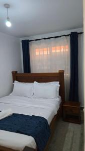 a bedroom with two beds and a window at Tulivu homes in Ongata Rongai 