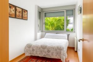 サン・アドリア・デ・ベソスにあるCCIB Forum Deluxe Apartmentのベッドと窓のある寝室