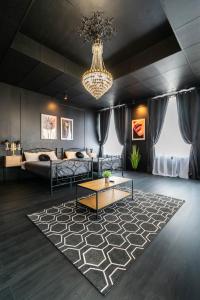 een woonkamer met een bank en een kroonluchter bij Apartments24 Black 1903 in Rakvere