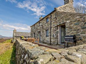 an old stone house with a stone wall at 6 Bed in Harlech 91546 in Harlech