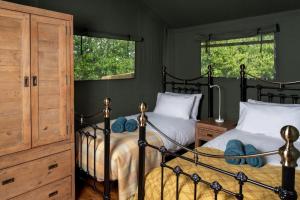 a bedroom with two beds and two windows at Hebog Glamping Lodge in Talybont