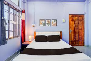 a bedroom with a large white bed and a window at Hotel O Dream Lodge in Nowgong