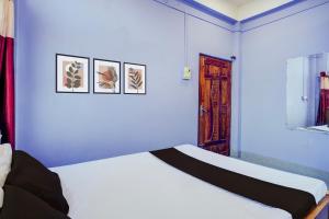 a bedroom with a white bed and three pictures on the wall at Hotel O Dream Lodge in Nowgong