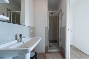 een witte badkamer met een wastafel en een douche bij Dali' in Parzanica +24 foto's