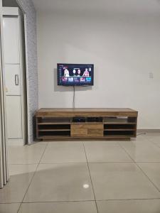 een woonkamer met een televisie aan de muur bij Loft encantador próximo a Roda Gigante,excelente localização com ar condicionado in Balneário Camboriú