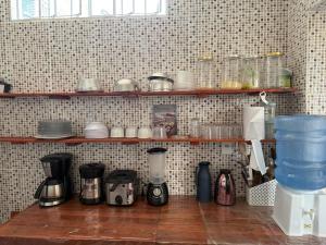 a kitchen with a shelf with cups and coffee makers at Quartos compartilhados COP30 - BRL in Belém