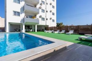 a hotel with a swimming pool and a building at Phoenix 2-Bedroom Apartment in Larnaca
