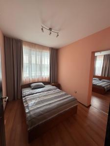 una camera da letto con un letto e uno specchio di Апартамент за гости Рачо Ковача a Gabrovo