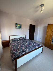 una camera da letto con un letto con copriletto floreale di Апартамент за гости Рачо Ковача a Gabrovo