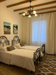 Un dormitorio con dos camas y una ventana. en Villa Fontis Rapolano, en Rapolano Terme