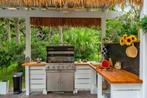 an outdoor kitchen with a stove and a table at 9BR Heated Pool Hot Tub Sleeps 25 in Largo