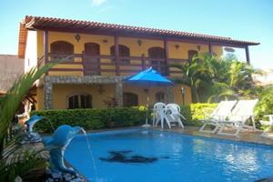 a house with a swimming pool in front of a house at Pousada Da Restinga in Cabo Frio +15 photos