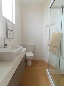 a white bathroom with a sink and a toilet at Mario401| Loft in Leblon next do Lagoa in Rio de Janeiro +7 photos
