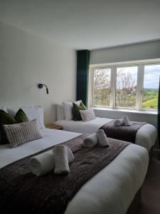 Un dormitorio con dos camas con toallas encima. en Hidden Acres- Deluxe Double & Single Room, en Malahide