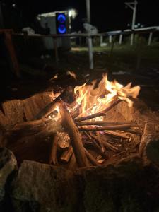 a fire pit with a pile of wood and fire at Mystic Valley Vattavada in Kottakamboor