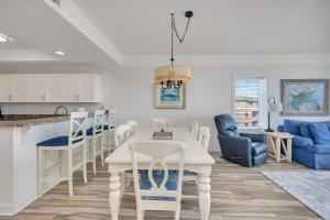 a kitchen and living room with a white table and chairs at St. Simons Grand #305 in Saint Simons Island