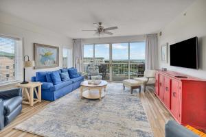 a living room with a blue couch and a tv at St. Simons Grand #305 in Saint Simons Island
