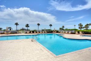 a large swimming pool with chairs and palm trees at St. Simons Grand #305 in Saint Simons Island