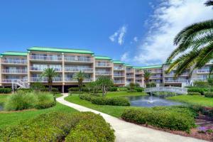 a resort with a pond and palm trees at St. Simons Grand #305 in Saint Simons Island