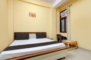 a bedroom with a bed and a chair and a window at Hotel O Namastay in Tapukrah