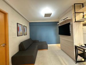 a living room with a couch and a flat screen tv at iFlat Lozandes Flamboyant Jardim Goiás in Goiânia