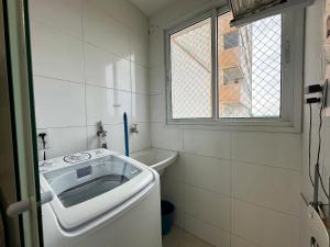 a white bathroom with a tub and a window at iFlat Lozandes Flamboyant Jardim Goiás in Goiânia