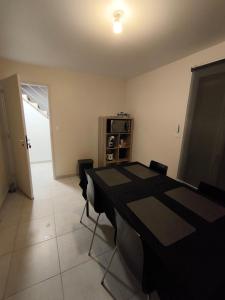 a dining room with a black table and chairs at Notre Dame d'Orgemont - Marron 6 in Argenteuil