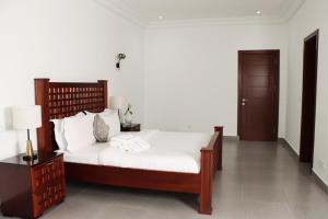 a bedroom with a large bed with white sheets at La Villa Grenade in Pointe-Noire