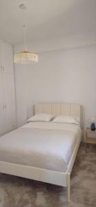 un lit blanc dans une chambre blanche avec un mur blanc dans l'établissement Persephone's Summer House Paros - 2BR Garden Villa, à Parasporos