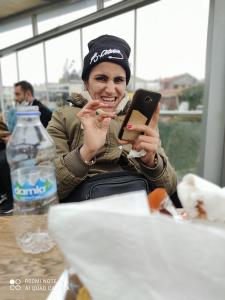 Een vrouw die aan een tafel zit en naar haar mobieltje kijkt. bij Ay suit in Esenyurt