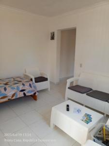 ein Wohnzimmer mit zwei Betten und einem Tisch in der Unterkunft Hogar cerca de la playa in Punta Cana + 1 Foto