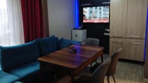 een woonkamer met een blauwe bank en een houten tafel bij Ay suit in Esenyurt