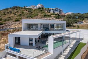 a large white house with a hill in the background at Villa Dominica in Páteo