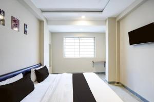 a room with a bed and a flat screen tv at Hotel O Eternity Stays in Harsola