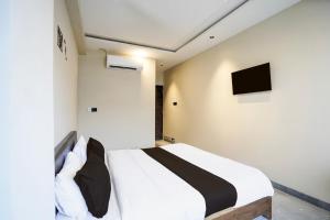 a bedroom with a bed and a tv on the wall at Hotel O Eternity Stays in Harsola