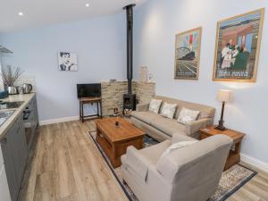 a living room with two couches and a fireplace at Rose Stables in Carterton