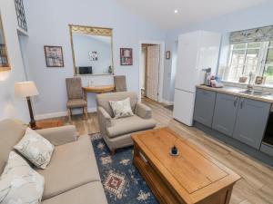 a living room with a couch and a table at Rose Stables in Carterton