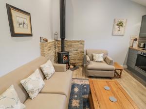 een woonkamer met een bank en een open haard bij Lily Stables in Carterton